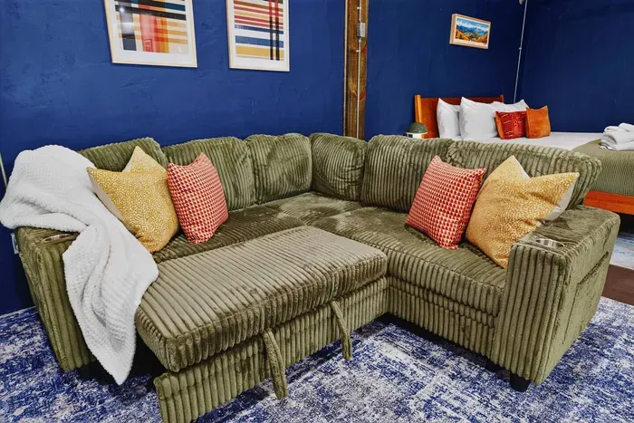 Cozy living area with a comfortable sectional sofa, colorful accent pillows, and a soft area rug.