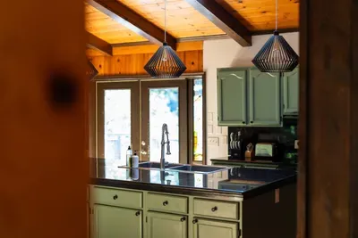 Stylish, fully equipped kitchen with a spacious island, modern fixtures, and warm rustic details.