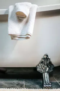 Thoughtful bathroom details with plush towels and elegant claw-foot tub accents.