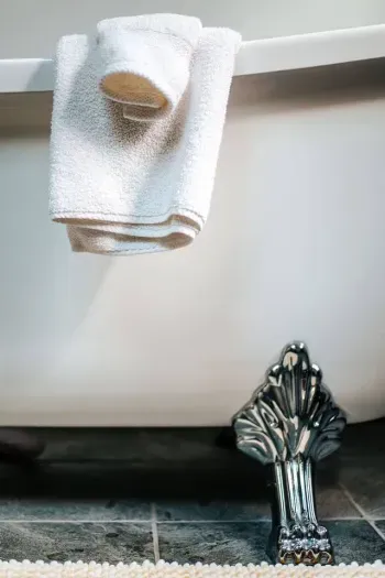 Thoughtful bathroom details with plush towels and elegant claw-foot tub accents.