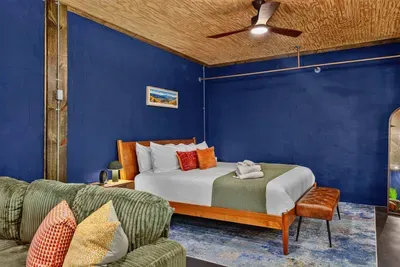 Comfortable Garden Suite bedroom with a king-size bed, fresh linens, cozy accents, and a warm wood ceiling.