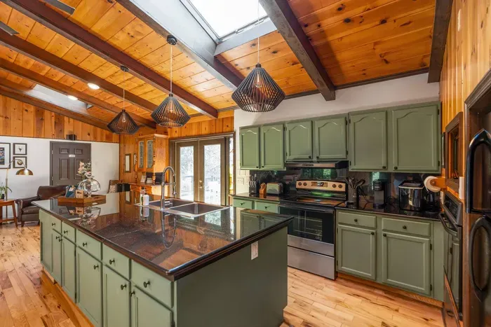 Fully Equipped Kitchen: Spacious kitchen with a large island, ample cabinetry, modern appliances, and warm wood accents—perfect for preparing meals and gathering together.