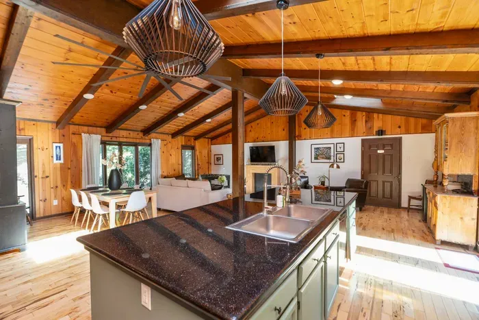 Open-Concept Great Room: Spacious kitchen, dining, and living areas flow together, with a large island, warm wood interiors, and plenty of natural light.