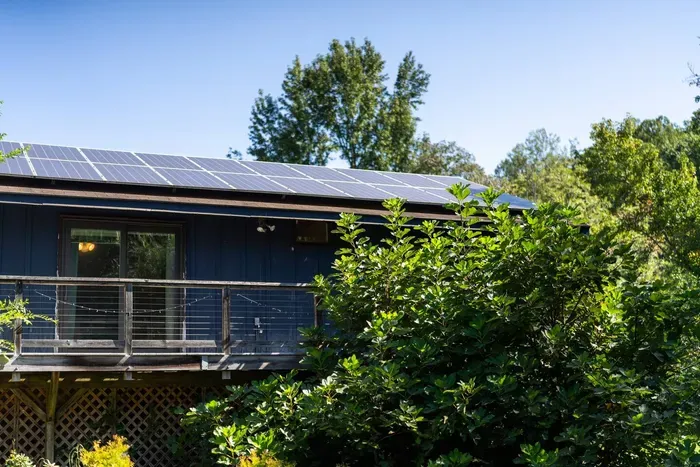 Peaceful woodland retreat with a private deck, lush greenery, and solar-powered charm.