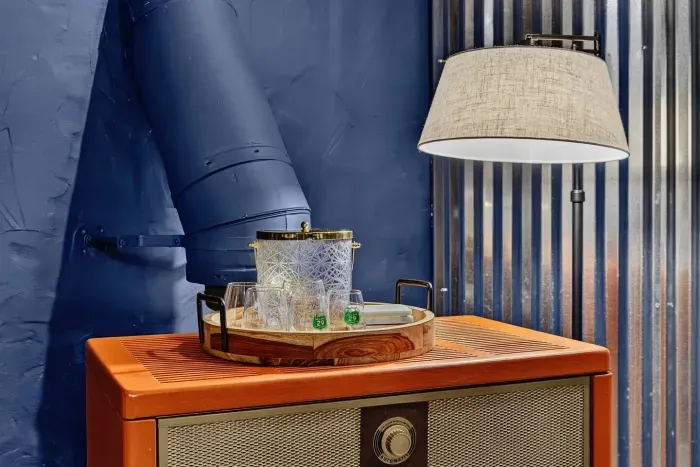 Cozy refreshment area with a drink tray, glassware, and a decorative lamp.