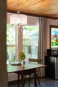 Sunny dining nook with crystal chandelier and garden-view windows