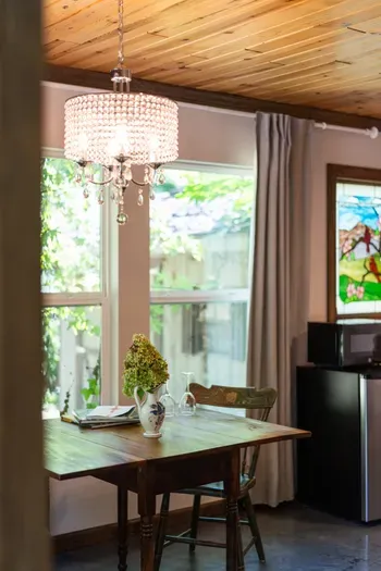 Sunny dining nook with crystal chandelier and garden-view windows