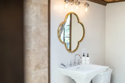 Elegant bathroom vanity with gold mirror and warm designer lighting