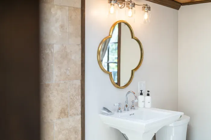 Elegant bathroom vanity with gold mirror and warm designer lighting