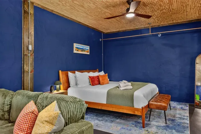 Comfortable Garden Suite bedroom with a king-size bed, fresh linens, cozy accents, and a warm wood ceiling.