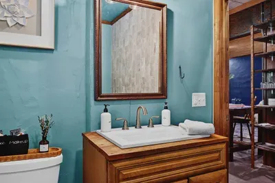 Garden Suite bathroom with a double vanity, large mirror, and warm wood cabinetry.