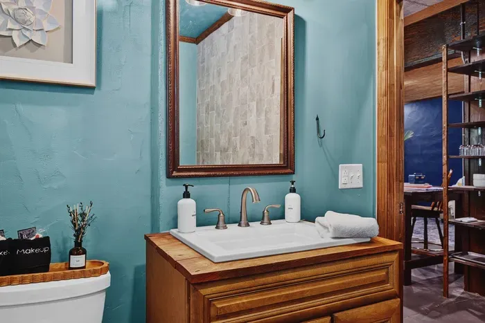 Garden Suite bathroom with a double vanity, large mirror, and warm wood cabinetry.