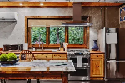 Fully equipped Garden Suite kitchen with modern appliances, a spacious island, and a beautiful view of the surrounding greenery.