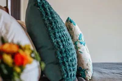 Cozy bedroom detail with soft bedding, textured pillows, and a warm, inviting atmosphere.