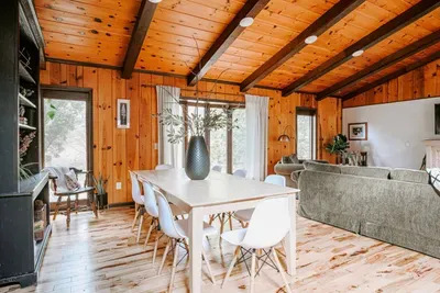 Bright, open dining area with warm wood accents, rustic charm, and peaceful woodland views.