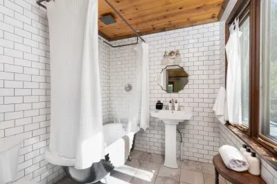 Bright, stylish bathroom with a walk-in shower, fresh towels, and charming wood accents.