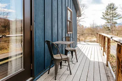 Spacious deck with outdoor seating and scenic woodland views, perfect for relaxing outdoors.