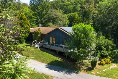 Charming woodland retreat with a private deck, lush greenery, and serene natural surroundings.