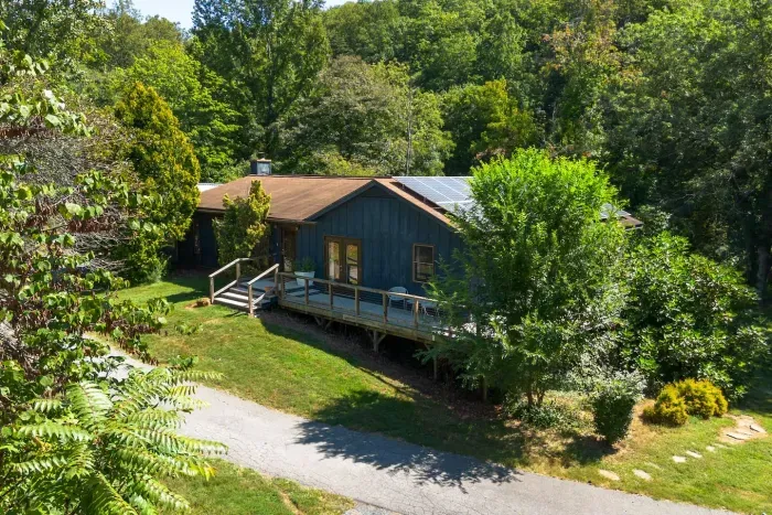 Charming woodland retreat with a private deck, lush greenery, and serene natural surroundings.