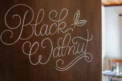 Charming room entrance featuring a hand-lettered “Black Walnut” door sign and warm natural light.