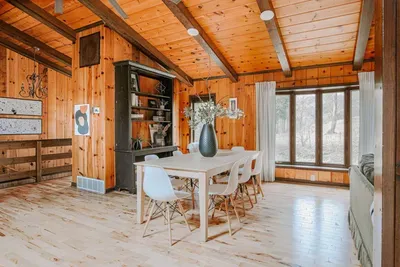 Bright, open dining area with warm wood accents, rustic charm, and peaceful woodland views.