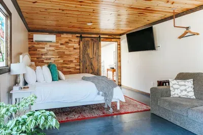 Cozy bedroom with a comfortable king bed, warm wood ceiling