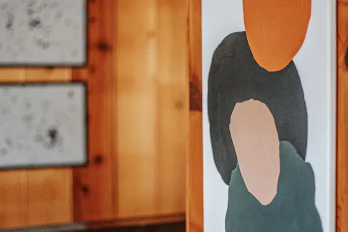 Modern abstract artwork adds a stylish artistic touch to the warm wood-paneled interior.