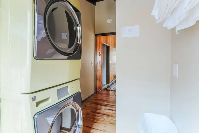 Laundry area with a convenient stacked washer and dryer, plus fresh linens ready for guests.