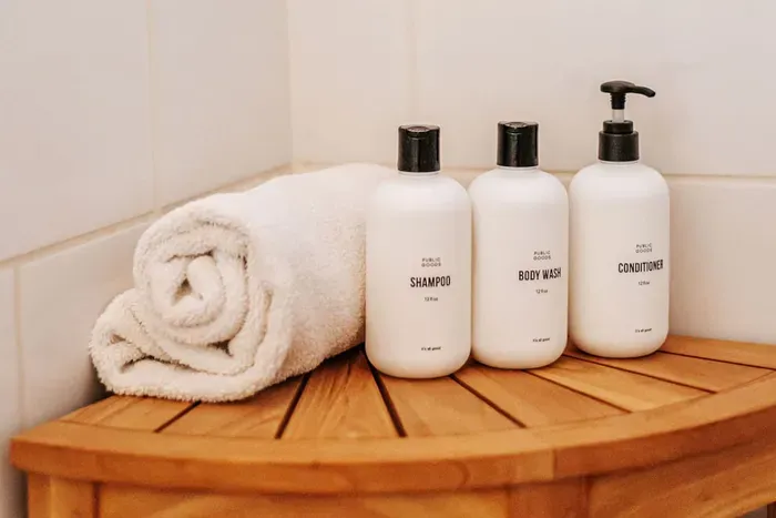 Modern bathroom amenities with shampoo, conditioner, towel, and body wash provided for guests.
