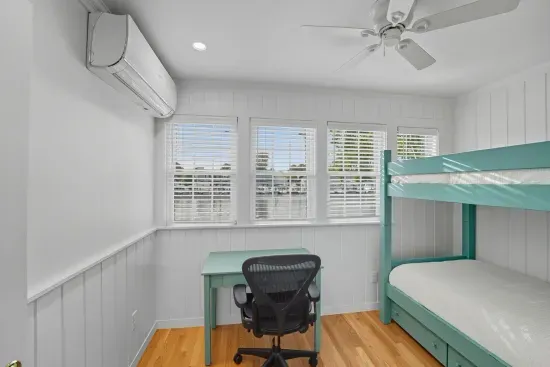 First floor bedroom with twin bunk beds and a mini split unit suppling heat and AC. No closet.