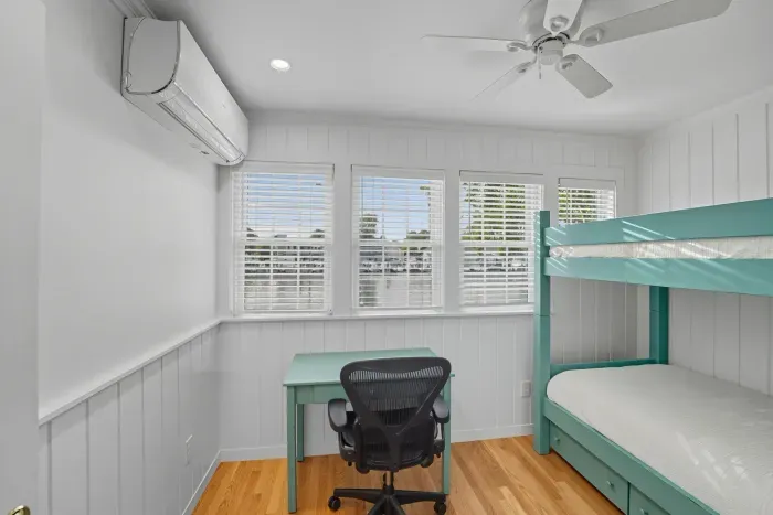 First floor bedroom with twin bunk beds and a mini split unit suppling heat and AC. No closet.