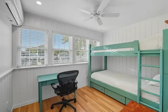 First floor bedroom with twin bunk beds and a mini split unit suppling heat and AC. No closet.