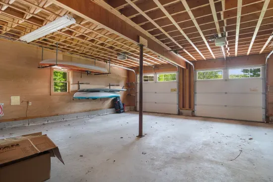 Large garage with 2 kayaks, 2 paddle boards, and a ping pong table. Gym is on second floor of garage.