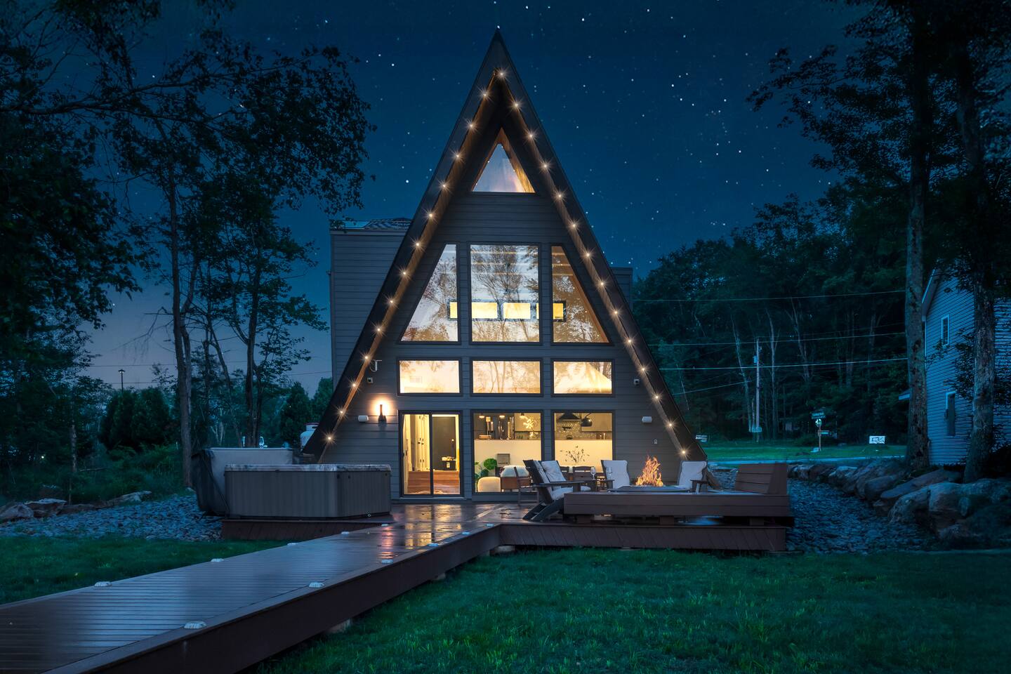 Under a starlit sky, Moonlit Peak’s glowing A-frame welcomes you with modern luxury and cozy charm — the perfect escape where evenings feel magical and memories are made!