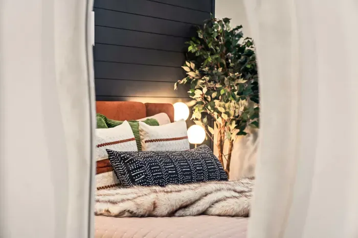 Cozy designer bedroom with layered bedding and warm ambient lighting