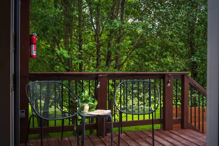 Private wooded deck with cozy seating for coffee and quiet moments