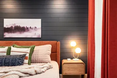 Cozy designer bedroom with bold accent wall and warm modern touches