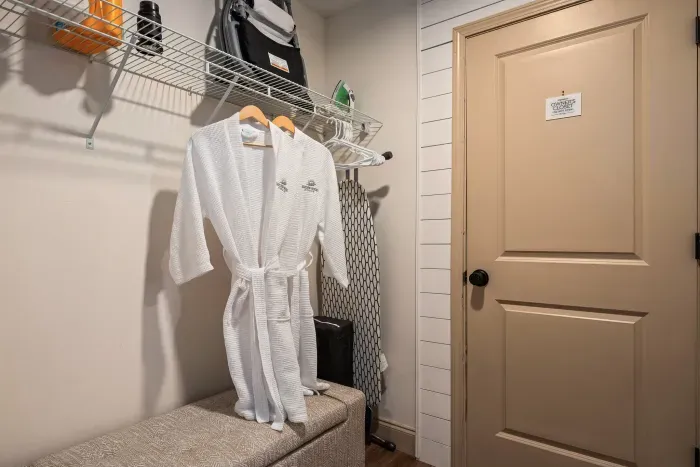Guest-ready dressing area with robes, storage, and a handy bench