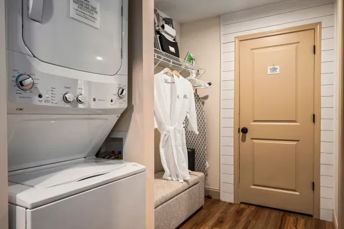 Convenient laundry nook with guest robes, bench seating, and extra storage