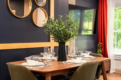 Stylish dining for 4 with designer decor, natural light, and bold accents