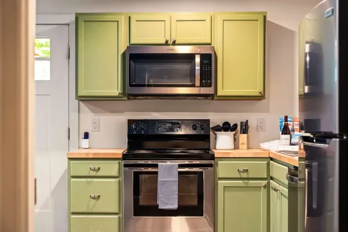 Bright kitchen with sage cabinets and full-size modern appliances