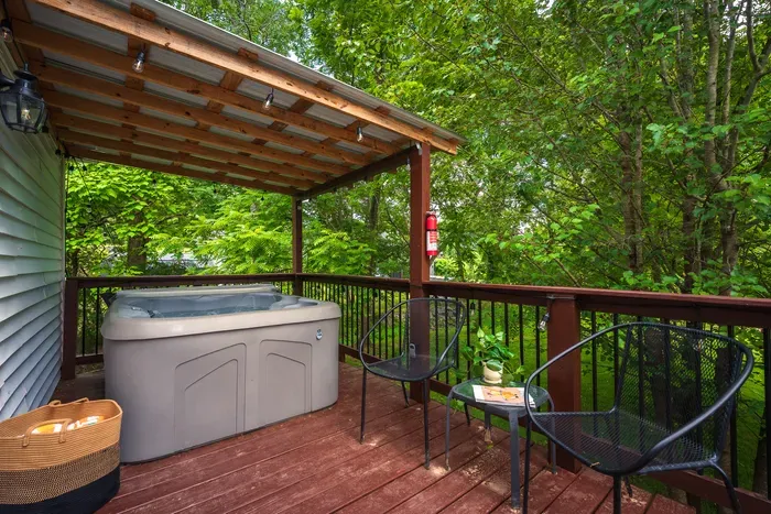 Private covered deck with hot tub and serene wooded views
