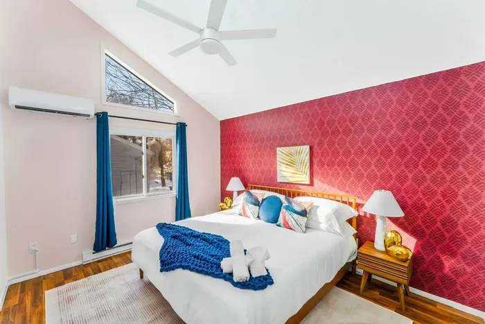 Sleep in style in this vibrant 2nd-floor bedroom featuring a plush king bed, vaulted ceilings, and bold design details.