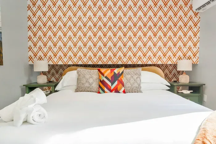 Bright, bold, and perfectly styled—this designer bedroom features crisp linens, colorful accents, and cozy touches that make winding down feel like a treat!