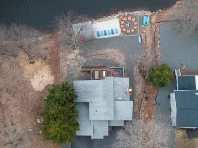 Bird’s-eye view of your private lakeside oasis—featuring direct water access, a spacious dock, cozy fire pit, and kayaks ready for your next adventure. Every inch of this property is designed for making memories year-round.