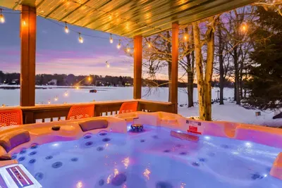 Soak in the warmth of the hot tub while enjoying breathtaking lake views.  Surrounded by twinkling string lights and a serene winter landscape, it's the perfect spot to unwind after a day of snow tubing, skiing, or outdoor adventures.