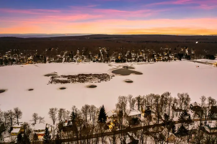 Serenity from above—an aerial winter view of the lakefront, where peaceful sunsets and snowy landscapes set the tone for a truly tranquil escape.