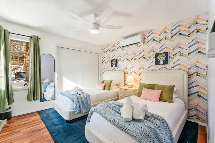 A soothing space with soft textures, blackout curtains, and a 55” smart TV—this peaceful twin room offers a quiet retreat for kids, teens, or friends to rest, recharge, and feel right at home.