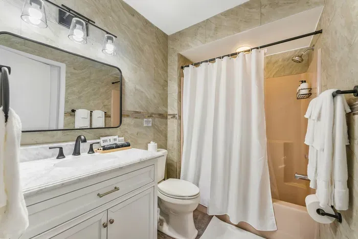 Fresh and elegant, this full bath features luxe finishes, a deep soaking tub, plush towels, hair dryer, and essential toiletries—perfect for winding down after lake adventures or bath time with the kids.