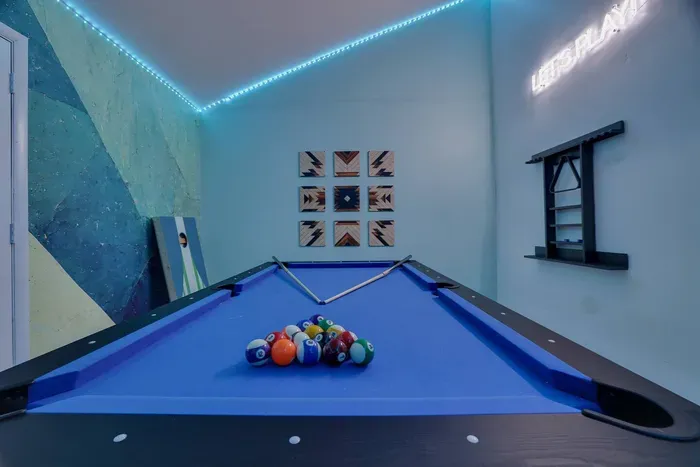 Cue up the fun in this stylish game room featuring a sleek pool table, LED lighting, and cool modern decor. The perfect space to unwind, compete, and make memories with family or friends.